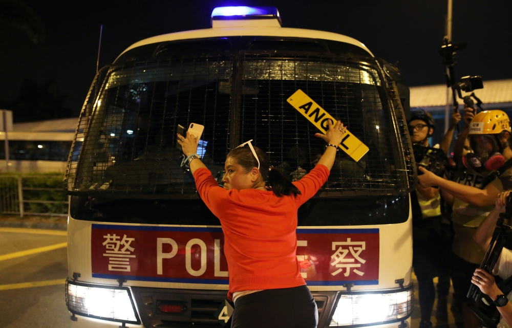 An anti-government demonstrator stands in fron of a police vehicle during a protest against the invocation of the emergency laws in Hong Kong, October 14, 2019. Reuters/Ammar Awad
 