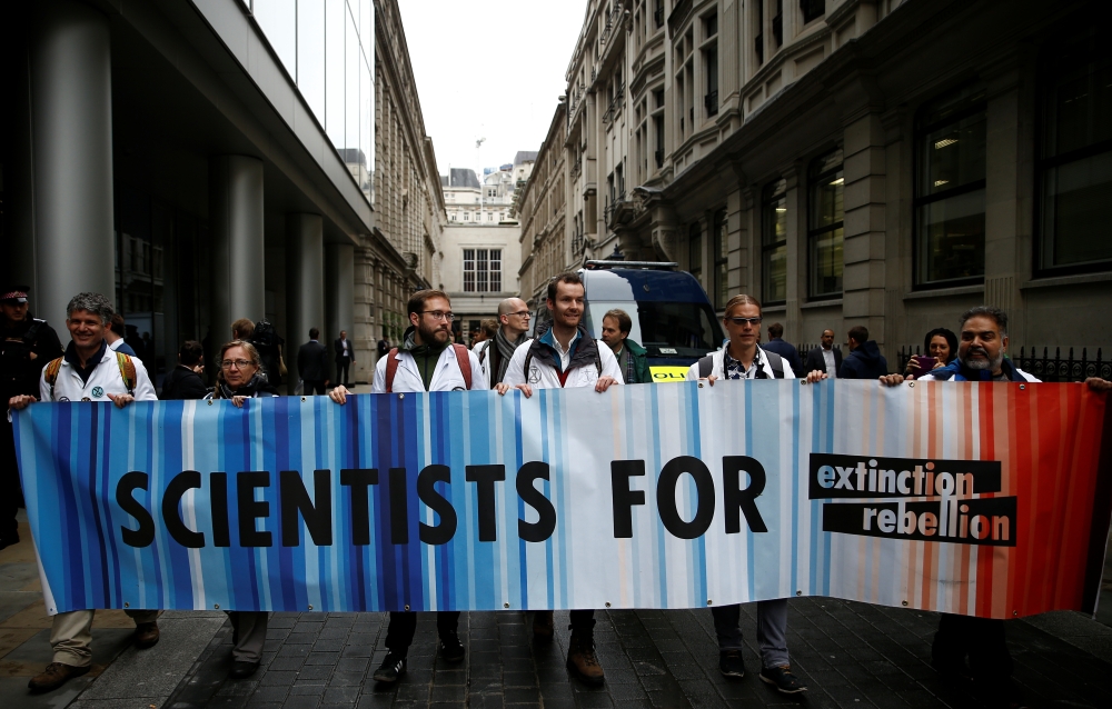 Protesters hold a banner outside the BlackRock office during an Extinction Rebellion demonstration in the City of London, Britain October 14, 2019. Reuters/Henry Nicholls