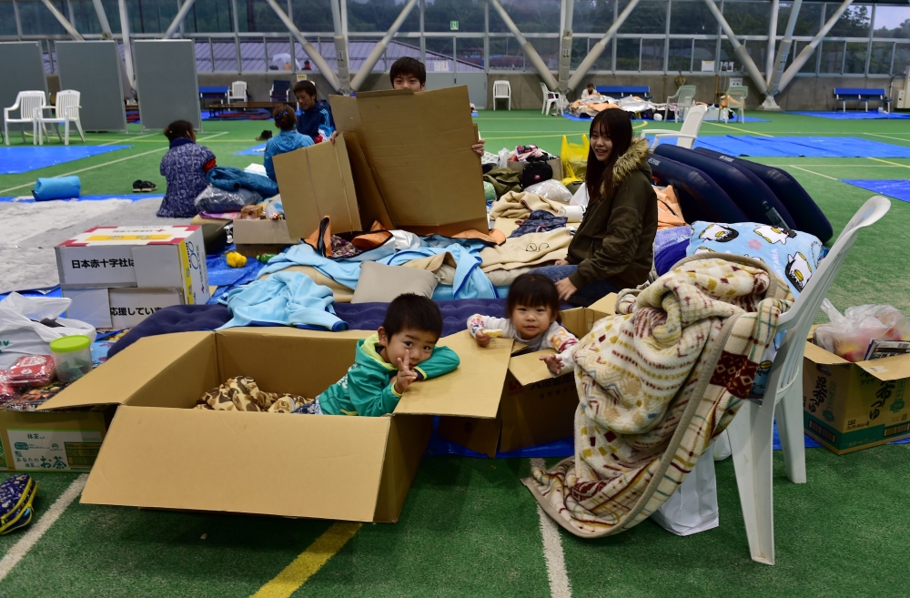 A family rest at an evacuation shelter in Nagano on October 14, 2019. AFP / Kazuhiro Nogi 