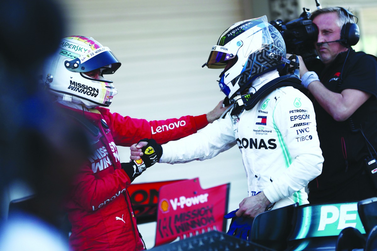 Winner Mercedes’ Finnish driver Valtteri Bottas (right) and second-placed Ferrari’s German driver Sebastian Vettel (left) congratulate one another after the Japanese Grand Prix final at Suzuka on Sunday.  