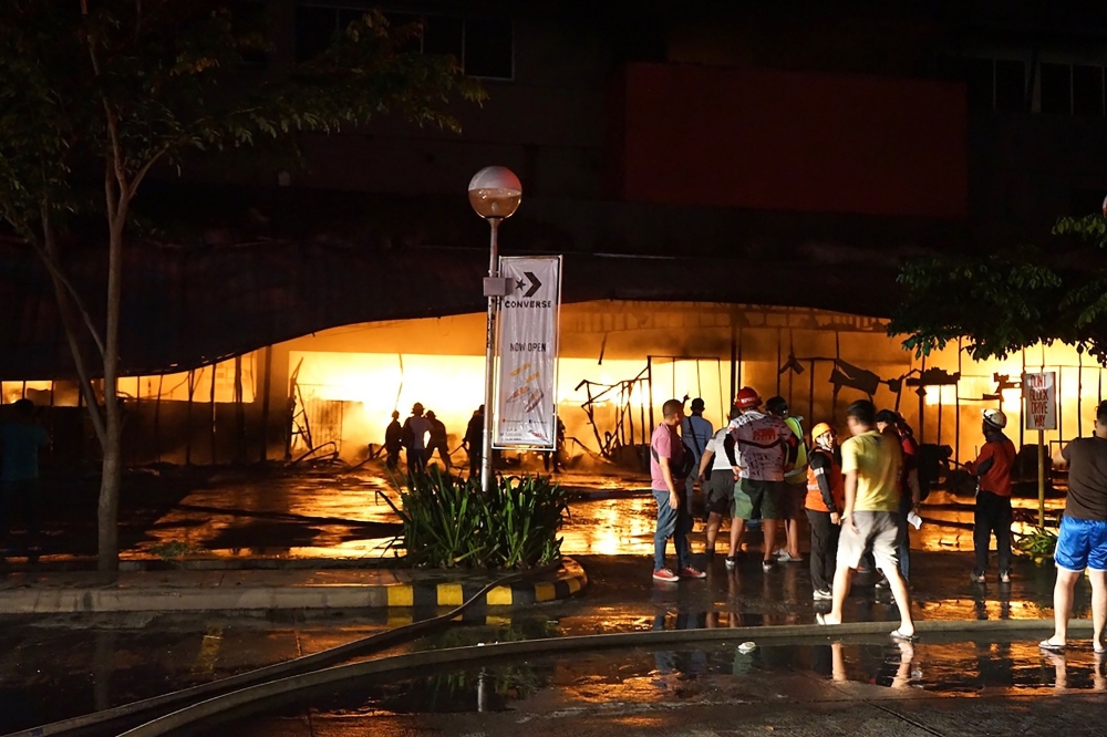 Firemen try to put out a fire on a mall following a 6.4-magnitude quake in General Santos City, in southern island of Mindanao, on October 16, 2019.  AFP / EDWIN ESPEJO AND EDWIN ESPEJO