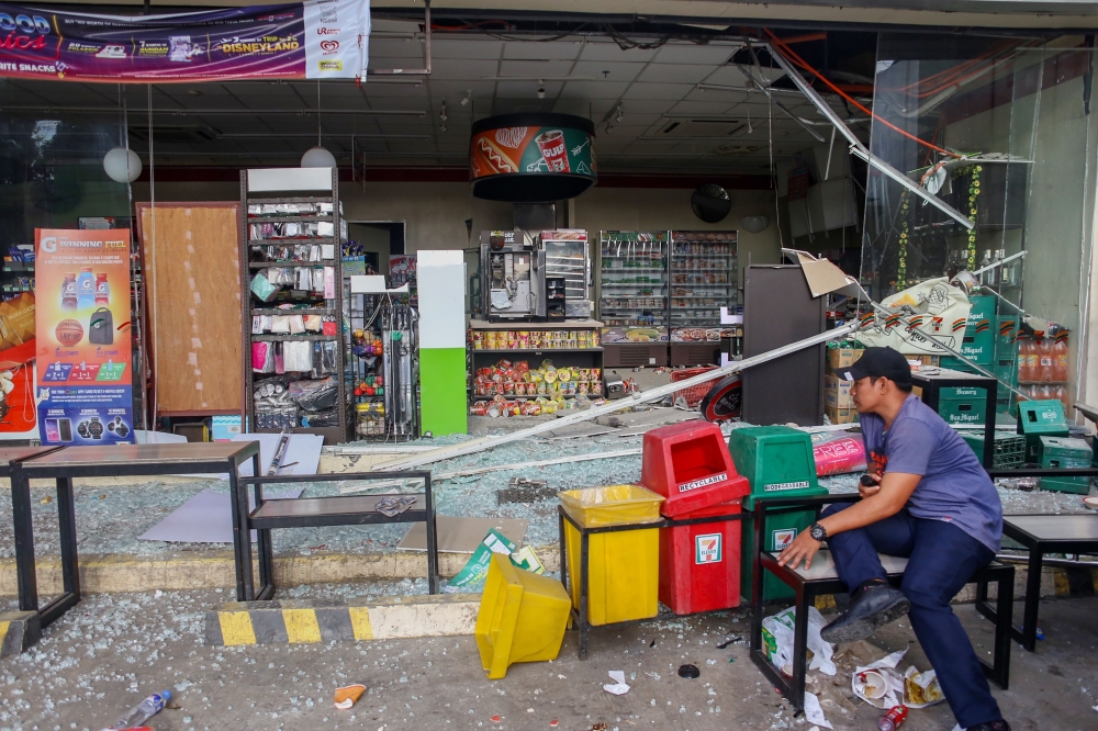 A store owner guards the remains of his store amidst debris after a 6.4 magnitude earthquake hit the night before in the city of Digos, Davao del Sur province on the southern Philippine island of Mindanao on October 17, 2019. AFP / Manman Dejeto