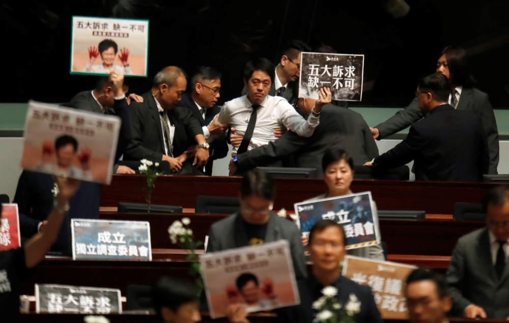 A pro-democracy lawmaker is escorted by security from the Legislative Council, as Hong Kong's Chief Executive Carrie Lam takes questions from lawmakers regarding her policy address, in Hong Kong, China October 17, 2019. REUTERS/Umit Bektas