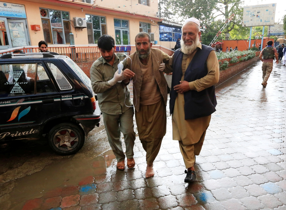 Men carry an injured person to a hospital after a bomb blast at a mosque, in Jalalabad, Afghanistan October 18, 2019. Reuters/Parwiz