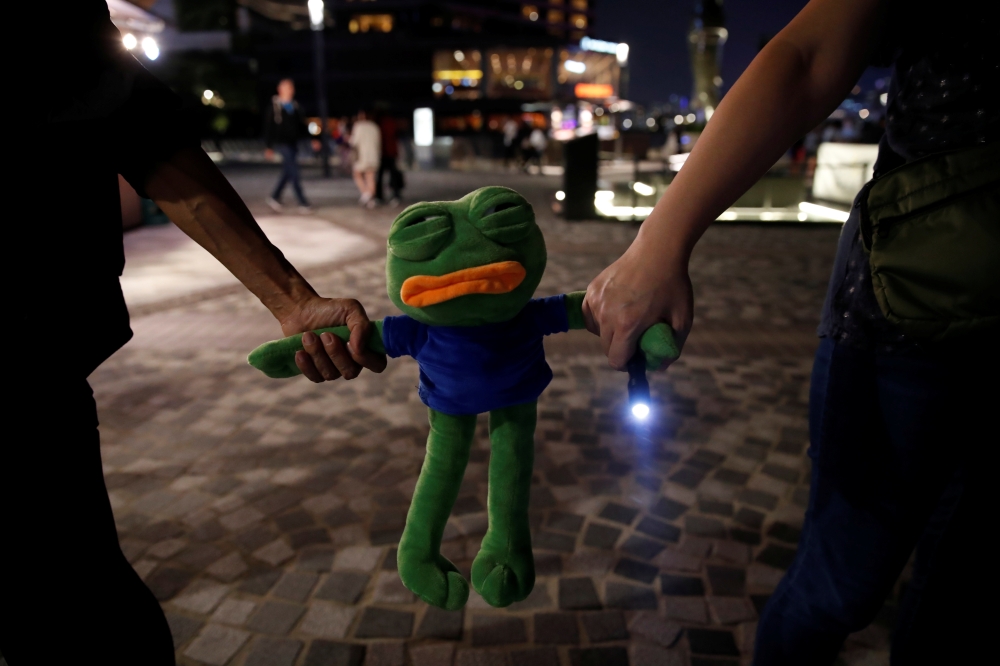 People holding a toy form a human chain during an anti-government protest in Hong Kong, China, October 18, 2019. REUTERS/Umit Bektas