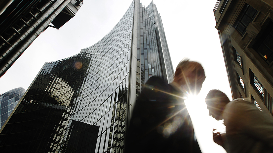 Pedestrians pass office blocks in the City of London, June 19, 2013. Reuters / Luke MacGregor