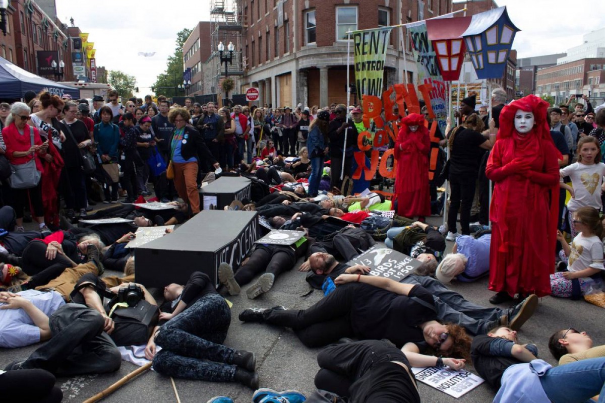 Extinction Rebellion members and those from immigrant, housing rights groups, participate in a four-minute long die-in upon arriving in Harvard Square in Cambridge, Massachusetts, at the end of the Honk! Festival march, October 13, 2019. Thomson Reuters F