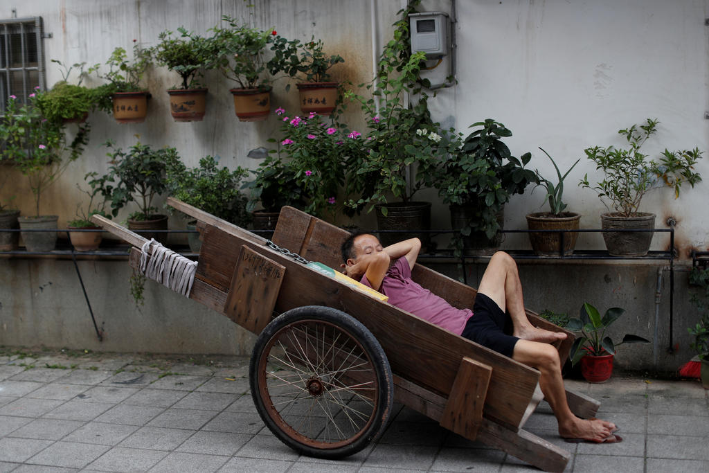 A man sleeps in a cart near a market in the traditional neighbourhood of Yuexiu in Guanghzou, China, September 8, 2019. Reuters/Jorge Silva