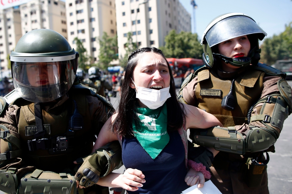 Riot police detain a demonstrator during a protest in Santiago, Chile, on October 21, 2019. AFP / Pablo Vera 