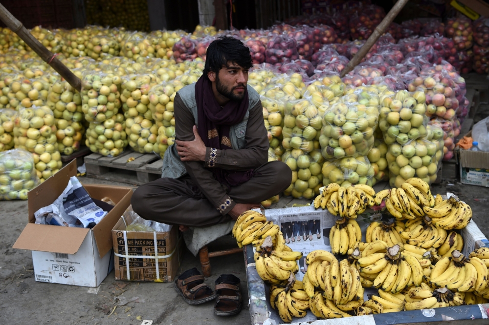 A fruit vendor waits for costumers at the fruit market in Kabul on October 22, 2019. AFP / Wakil Kohsar 