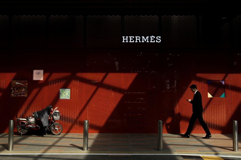 A man walks past a store of luxury goods retailer Hermes one day before the opening session of the National People's Congress (NPC) in Beijing, China March 4, 2019. Reuters/Thomas Peter