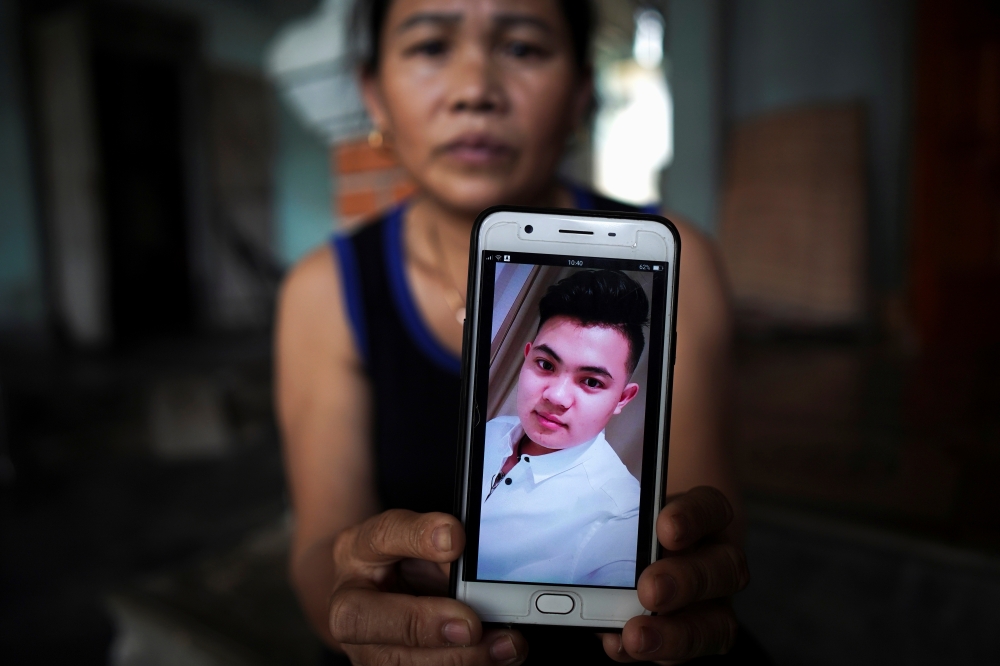 Hoang Thi Ai, 48, mother of Hoang Van Tiep who is one of the suspected victims of the 39 people found dead in a refrigerated truck in Britain, shows a picture of him on her mobile phone at her house, in Dien Chau district, Nghe An province, Vietnam, Octob