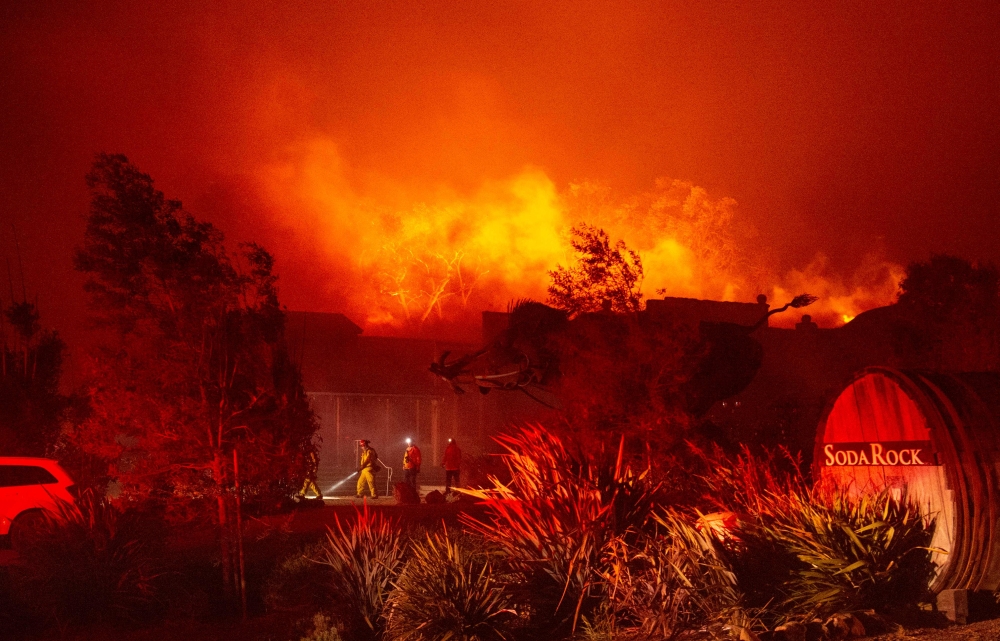 Firefighters survey Soda Rock Winery as it begins to burn during the Kincade fire in Healdsburg, California on October 27, 2019.  / AFP / Josh Edelson 