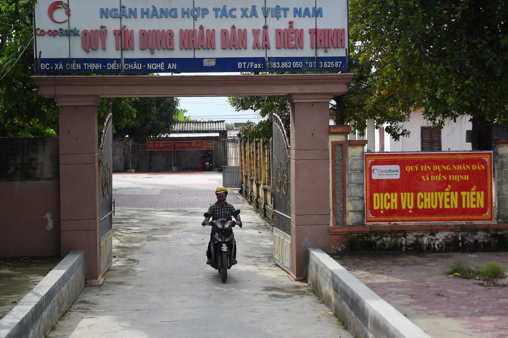 A motorist leaves a People's Credit Fund office, from where local residents can borrow money in Dien Thinh commune of Vietnam's Nghe An province on October 28, 2019. AFP / NHAC NGUYEN