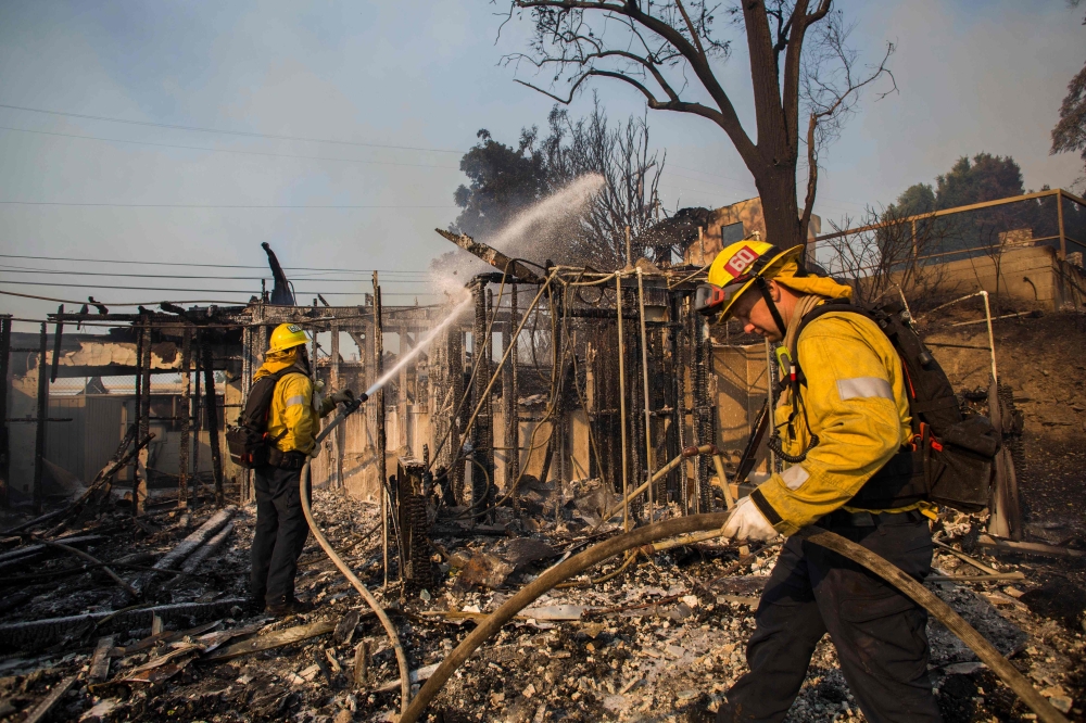 Firefighters battle the Getty Fire in houses on fire in Brentwood, California on October 28, 2019.  AFP / Apu Gomes 