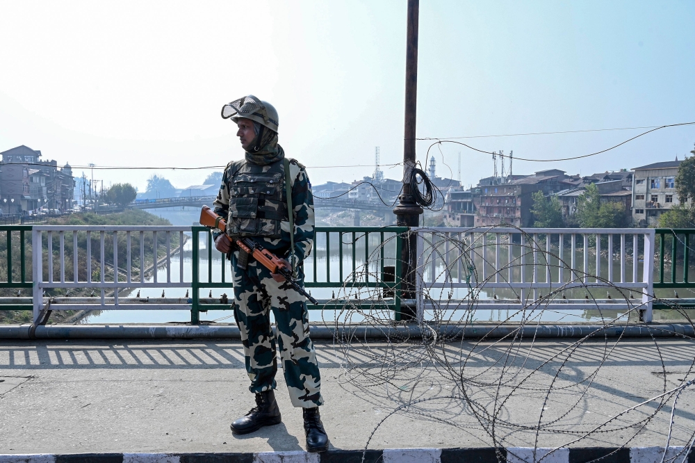A security personnel looks on as he stands guard during a lockdown in Srinagar on October 25, 2019. Suspected militants shot dead two non-local drivers and set their apple trucks ablaze in Indian-Administered Kashmir, police said on October 25, the latest