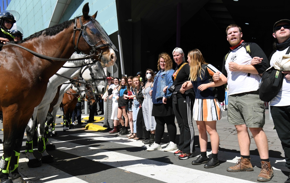 Climate change protesters attempting to blockade link arms in front of ploice horses at the International Mining and Resources Conference (IMARC) being held in Melbourne on October 29, 2019. More than 40 protesters were arrested and four policemen injured