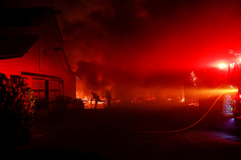 Firefighters work to contain a burning structure during the wind-driven Kincade Fire in Windsor, California, U.S. October 27, 2019. REUTERS/Stephen Lam
