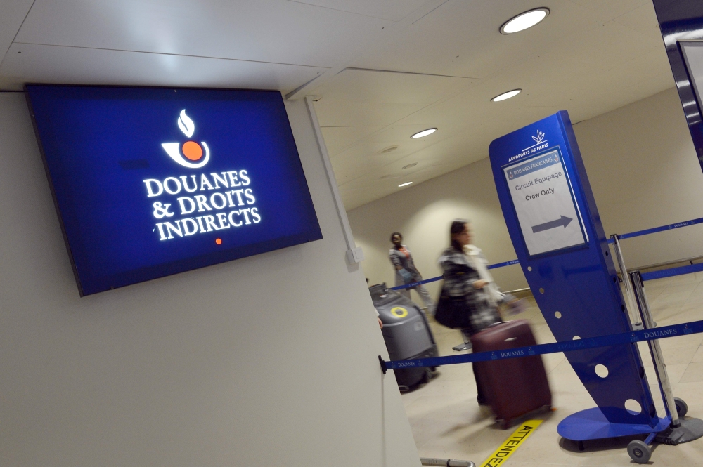 In this file photograph taken on December 28, 2012, shows passengers as they the logo of the French customs (douanes) at Orly airport, south of Paris. AFP / Miguel Medina 