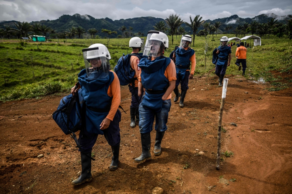 FARC-EP ex-combatant Edwin Correa (2-L) and former fellow fighters take part in a humanitarian demining training in the municipality of La Montanita, Caqueta, Colombia, on October 9, 2019. AFP / Juan Barreto 
