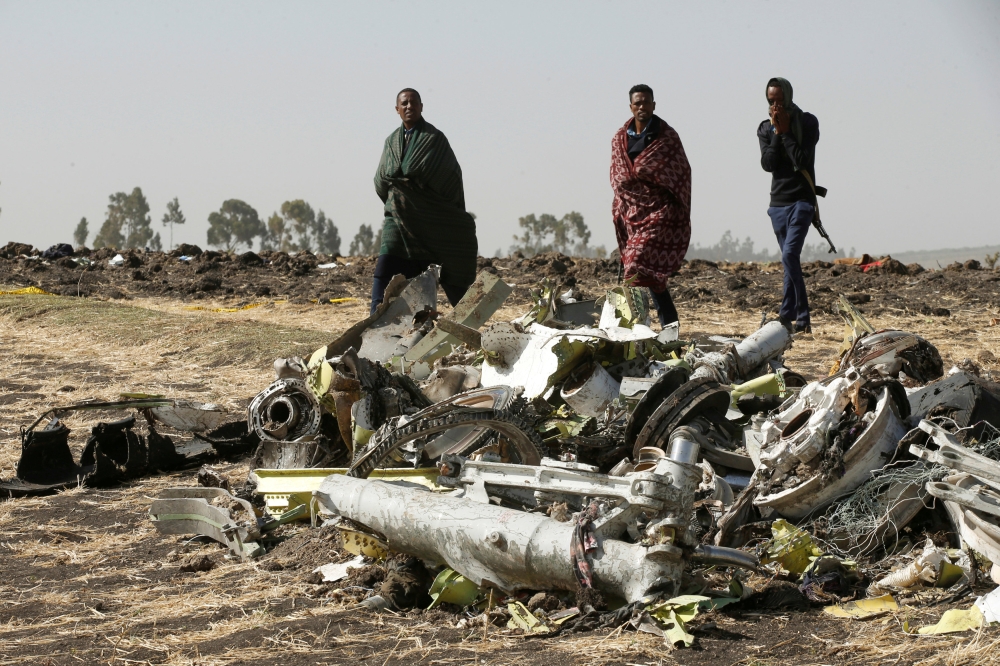 Ethiopian police officers walk past the debris of the Ethiopian Airlines Flight ET 302 plane crash near the town of Bishoftu near Addis Ababa, Ethiopia, March 12, 2019. Reuters / Baz Ratner