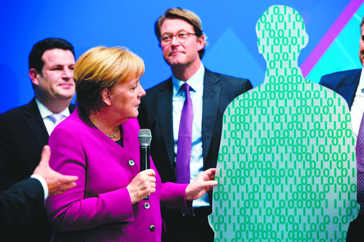 German Minister of Labour and Social Affairs Hubertus Heil (L), German Chancellor Angela Merkel and German Transport Minister Andreas Scheuer (R) attend a presentation during their visit at the Digital Summit (Digital Gipfel) in Dortmund, western Germany,