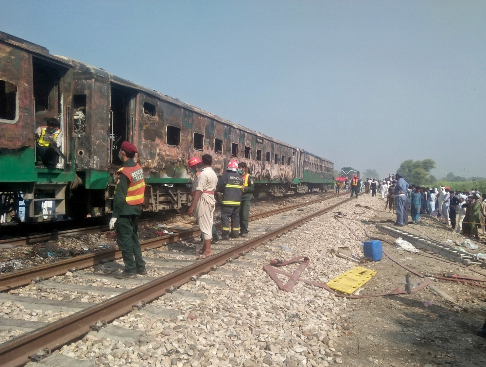 People and rescue workers gather near the site after a fire broke out in a passenger train and destroyed three carriages near the town of Rahim Yar Khan, Pakistan October 31, 2019. REUTERS/Stringer
 