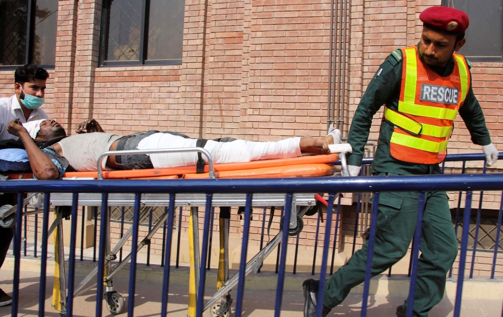 Rescue workers bring an injured victim to a hospital in Multan on October 31, 2019, after a passenger train caught on fire near Rahim Yar Khan in Punjab province. AFP / Mansoor Abbas 
 