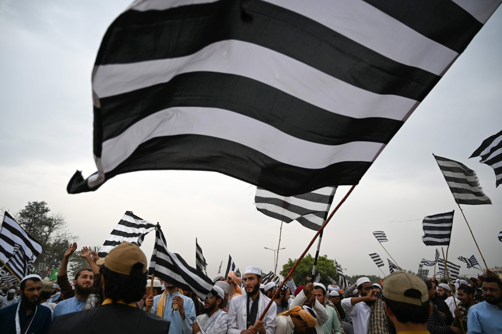 Activists and supporters of Islamic political party Jamiat Ulema-e-Islam (JUI-F) wave flags during anti-government 