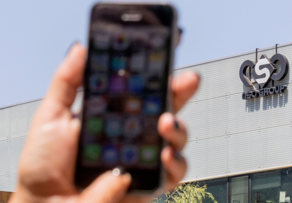In this file photo taken on August 28, 2016 an Israeli woman uses her iPhone in front of the building housing the Israeli NSO group, in Herzliya, near Tel Aviv.  AFP / Jack Guez
 