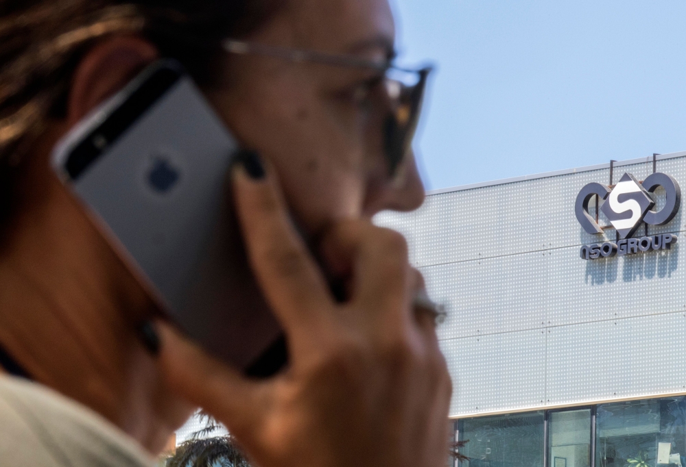 In this file photo taken on August 28, 2016 an Israeli woman uses her iPhone in front of the building housing the Israeli NSO group, in Herzliya, near Tel Aviv. AFP / Jack Guez
 