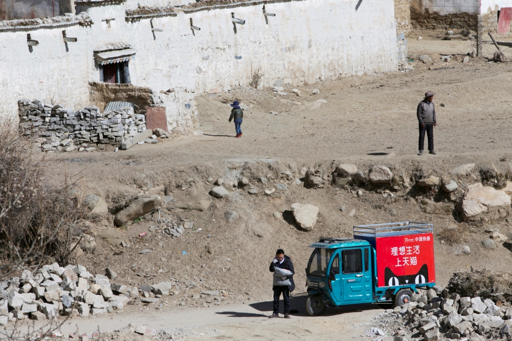  A delivery man of Alibaba's logistics unit Cainiao talks on a phone as he delivers a parcel in Lhasa, Tibet Autonomous Region, China January 13, 2018. Reuters