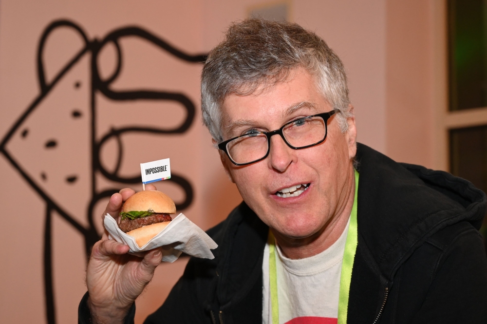 Impossible Foods CEO Pat Brown holds up an Impossible Burger 2.0, the improved version of plant-based vegan burger that tastes real beef at a press event during CES 2019 in Las Vegas on January 7, 2019. AFP / Robyn Beck