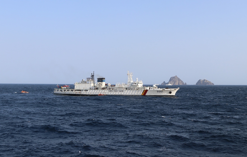This handout photo taken on November 1, 2019, and provided by the Korea Coast Guard shows rescue members searching for missing people after a helicopter crashed into the sea near the Dokdo islets, known as Takeshima in Japan