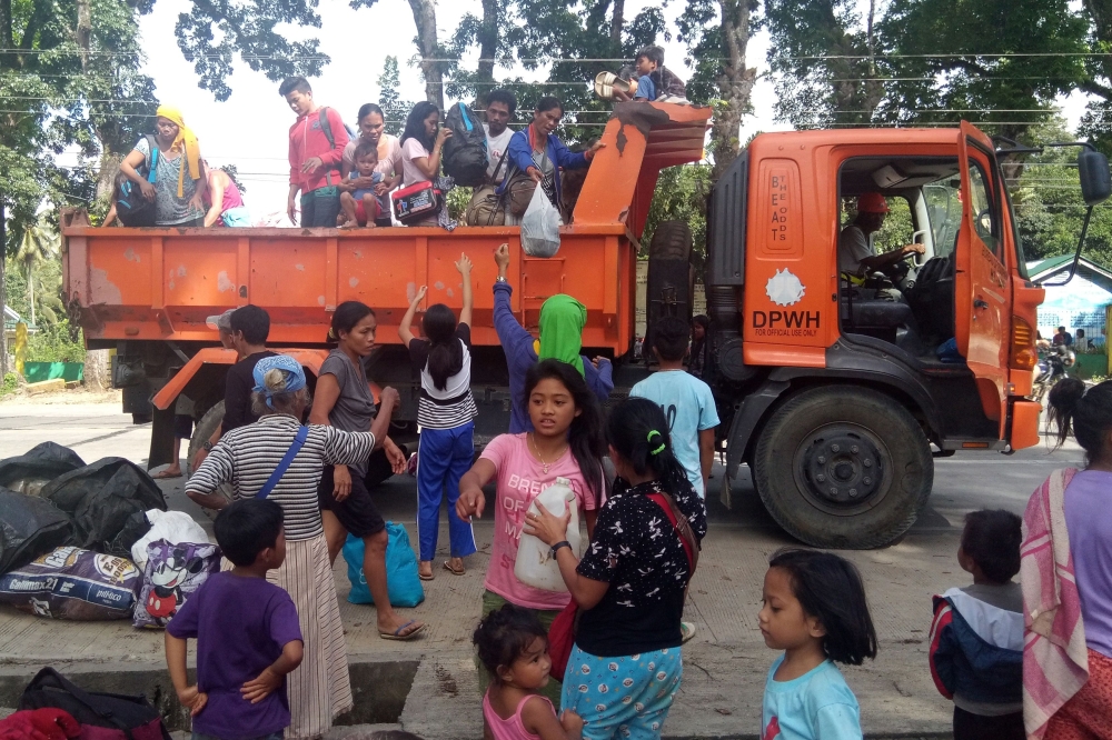 Residents, whose village were affected by a landslide due to a 6.5-magnitude earthquake, disembark from a government truck at a school compound in Makalila town, north Cotabato province, on November 1, 2019, a day after a powerful earthquake struck Mindan