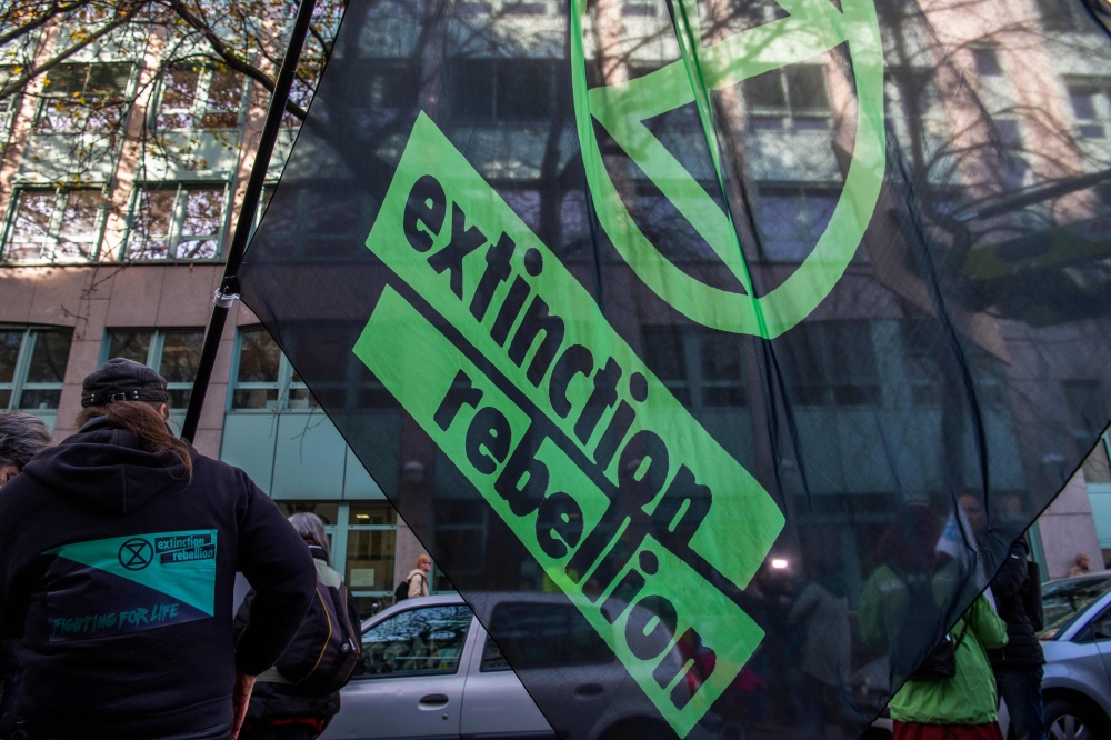 An activist waves an Extinction Rebellion flag during a demonstration in front of the Moabit administrative court in Berlin on October 31, 2019. AFP / John MACDOUGALL