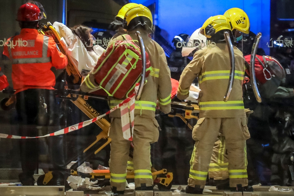 Paramedics carry away a wounded person on a stretcher after a bloody knife fight broke out at a shopping mall in Hong Kong on November 3, 2019.  AFP / VIVEK PRAKASH