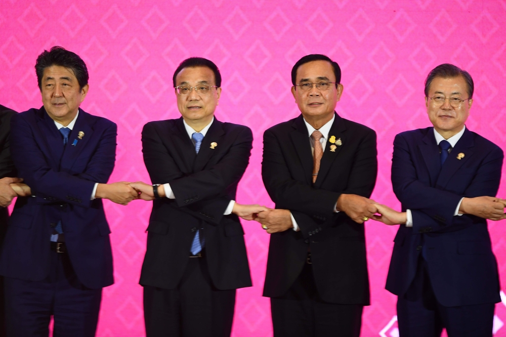 (From L to R) Japan's Prime Minister Shinzo Abe, China's Premier Li Keqiang, Thailand's Prime Minister Prayut Chan-O-Cha and South Korea's President Moon Jae-in pose for a group photo during the 22nd ASEAN Plus Three Summit in Bangkok on November 4, 2019,