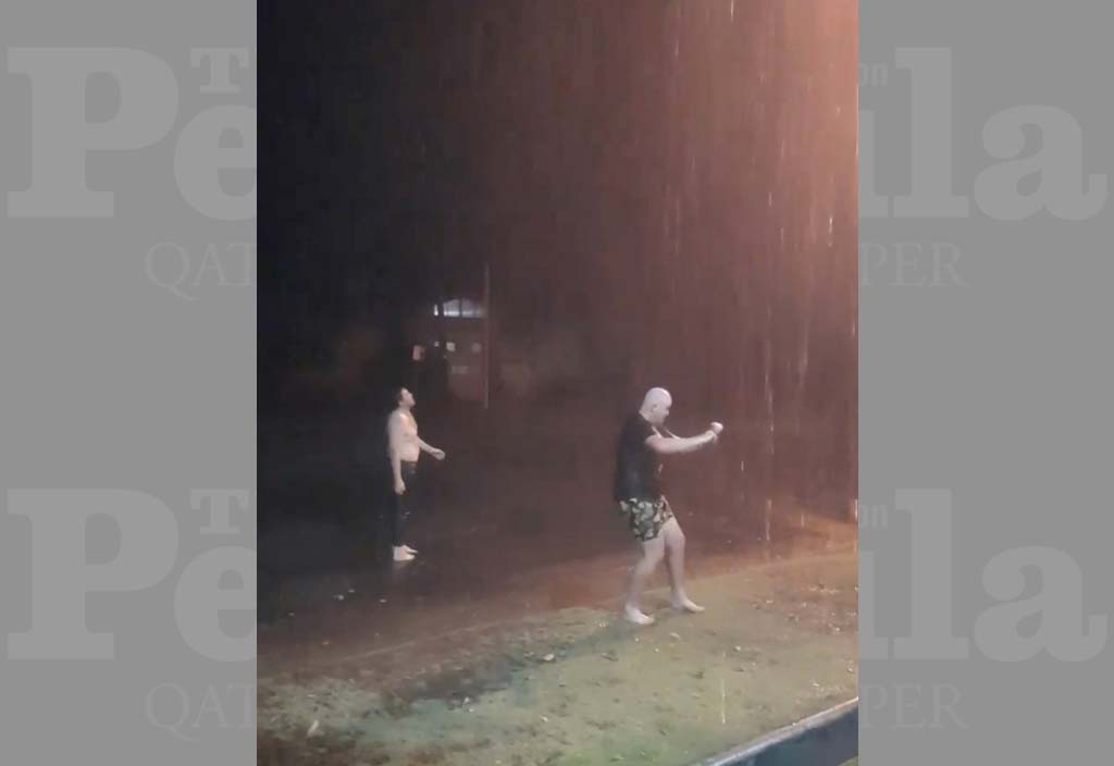 Men dance in the rain as they celebrate the first rainfall following a drought in Bourke, New South Wales, Australia November 2, 2019 in this picture obtained from social media. THE PORT OF BOURKE HOTEL/via REUTERS