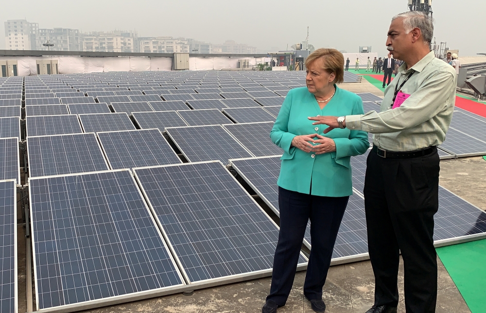 German Chancellor Angela Merkel speaks with an officer during her visit to a solar-powered metro station at Dwarka in New Delhi, India, November 2, 2019. Reuters/Andreas Rinke