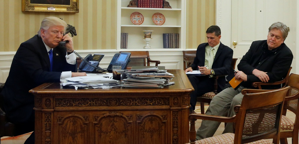 Donald Trump, seated at his desk with National Security Advisor Michael Flynn and senior advisor Steve Bannon speaks by phone with Australian PM Malcolm Turnbull, January 28, 2017. Reuters/Jonathan Ernst