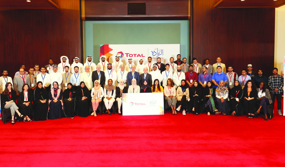 The participants posing for a group photo with Total officials.