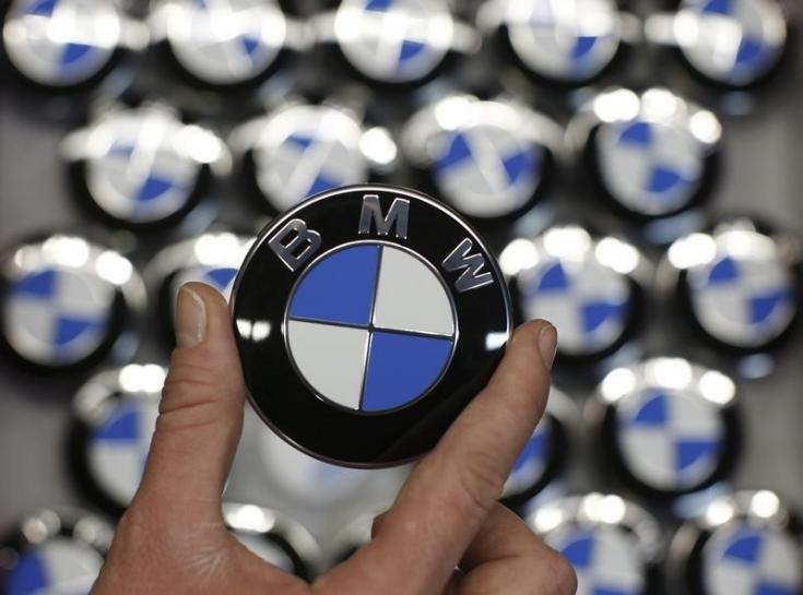 An employee holds a BMW logo on the production line of the BMW C evolution electric maxi-scooter at the BMW Berlin motorcycle plant, February 23, 2015. Reuters / Fabrizio Bensch