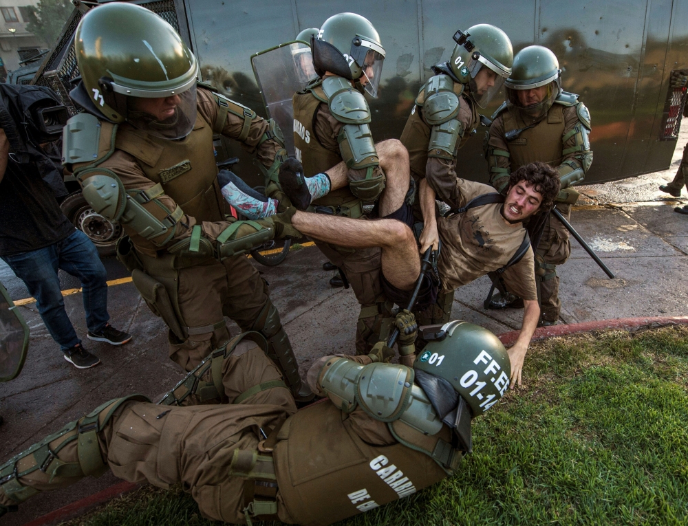 A demonstrator is arrested by riot police during a protest for the death of Mapuche Camilo Catrillanca in Santiago on November 15, 2018. AFP / Martin Bernetti