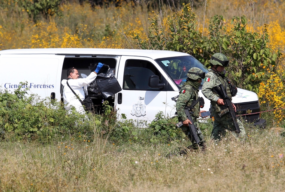 A team of forensic experts work in the site where seven bodies were found inside three abandoned vehicles on the way to Ocotillo, in Tonala, Mexico, on November 6, 2019. AFP / Ulises Ruiz
 