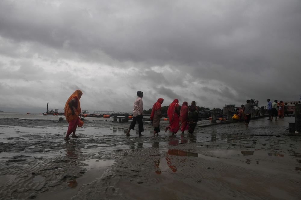 Hindu pilgrims walk by the dock after a ferry service to Sagar Island was suspended due to the approaching Cyclone Bulbul in Kakdwip in West Bengal state on November 9, 2019. Cyclone Bulbul, packing a maximum wind speed of 120 kilometres per hour (75 mile