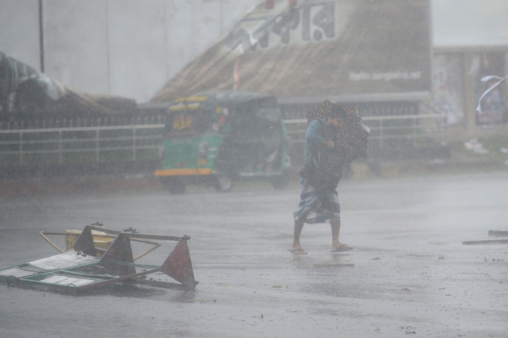 A pedestrian makes his way under heavy rain as cyclone Bulbul approaches the area in Khulna on November 10, 2019. AFP / Munir Uz Zaman 