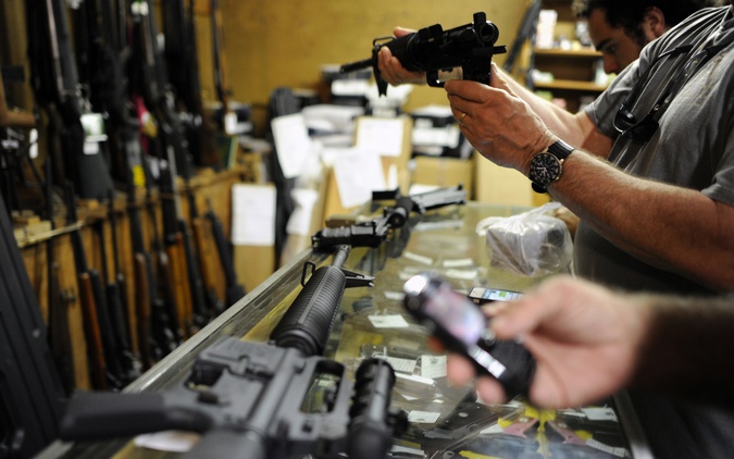Customers look over the last two AR-15 style rifles for sale inside the Bullet Hole gun shop in Sarasota, Florida. (Reuters file photo) 