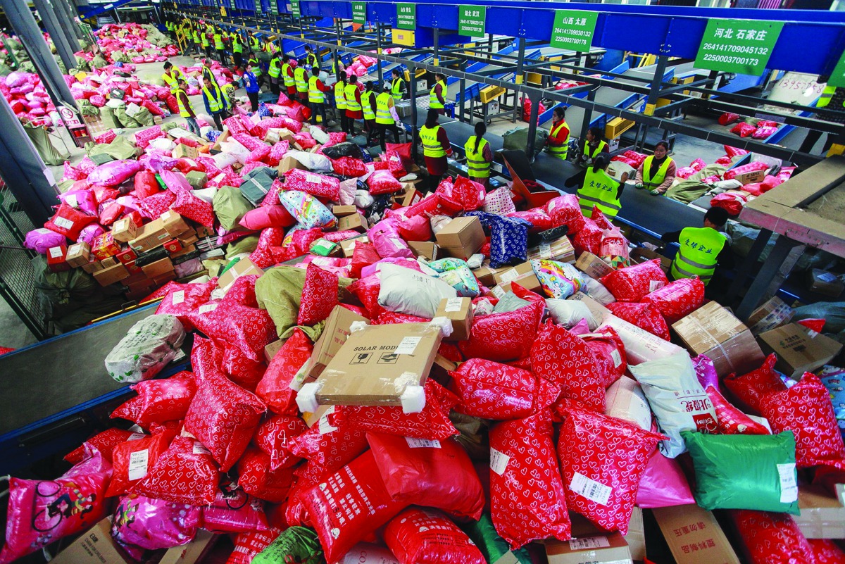 This photo taken on November 11, 2019 shows workers sorting out packages at a delivery company warehouse on 