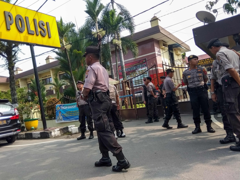 Indonesian police secure their headquarters in Medan, North Sumatra, on November 13, 2019, after a suicide attack occurred during their morning roll call. A suspected suicide bomber blew himself up outside a police station in Indonesia with at least one o